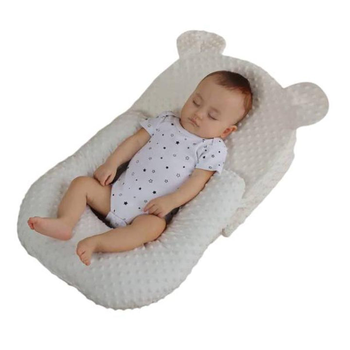 Ergonomic nursing pillow providing adjustable support for a comfortable baby.