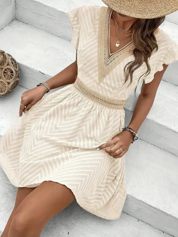 Casual summer women's mini dress with flutter sleeves & V-neck. Textured apricot fabric, perfect for daily wear.
