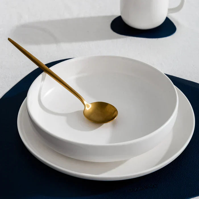 Aurora modern gold cutlery set arranged beautifully on an elegant dinner plate.