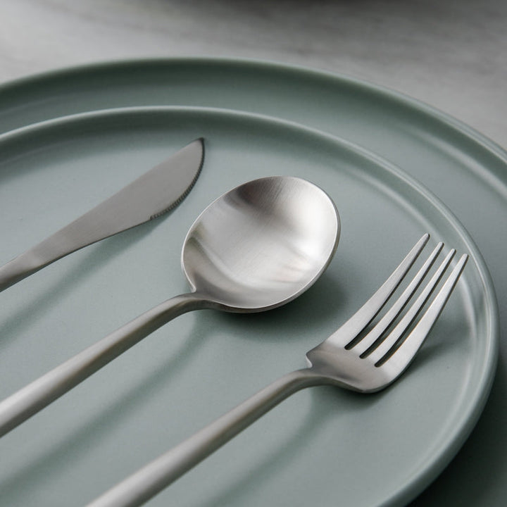Modern Aurora gold cutlery set, ready for elegant dinner parties.