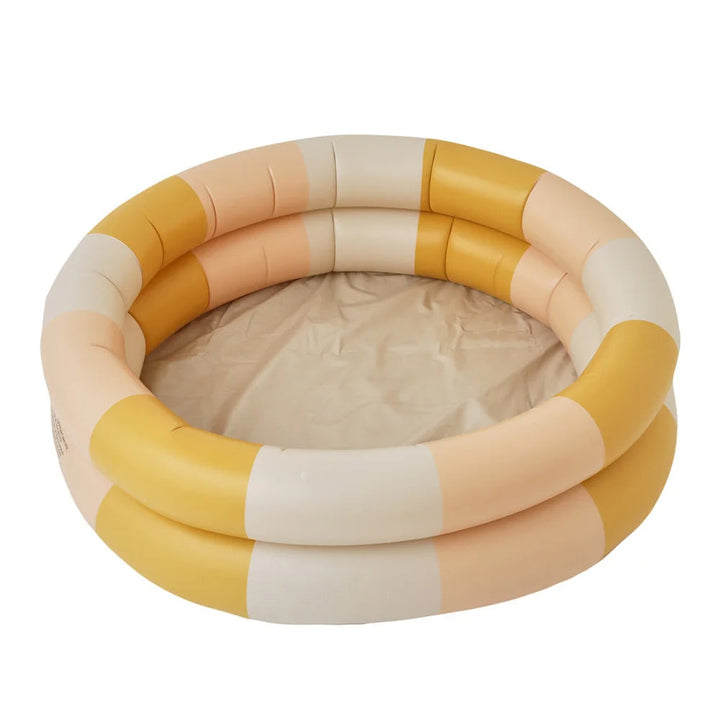 Happy baby splashing in an inflatable backyard pool with water toys