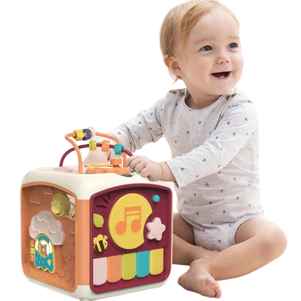 Toddler playing with a colorful baby piano toy that also features a drum.