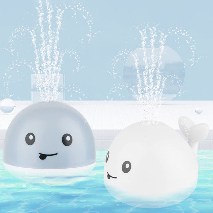 Interactive water sprinkler whale toy for babies, featuring colorful LED lights and safe design.