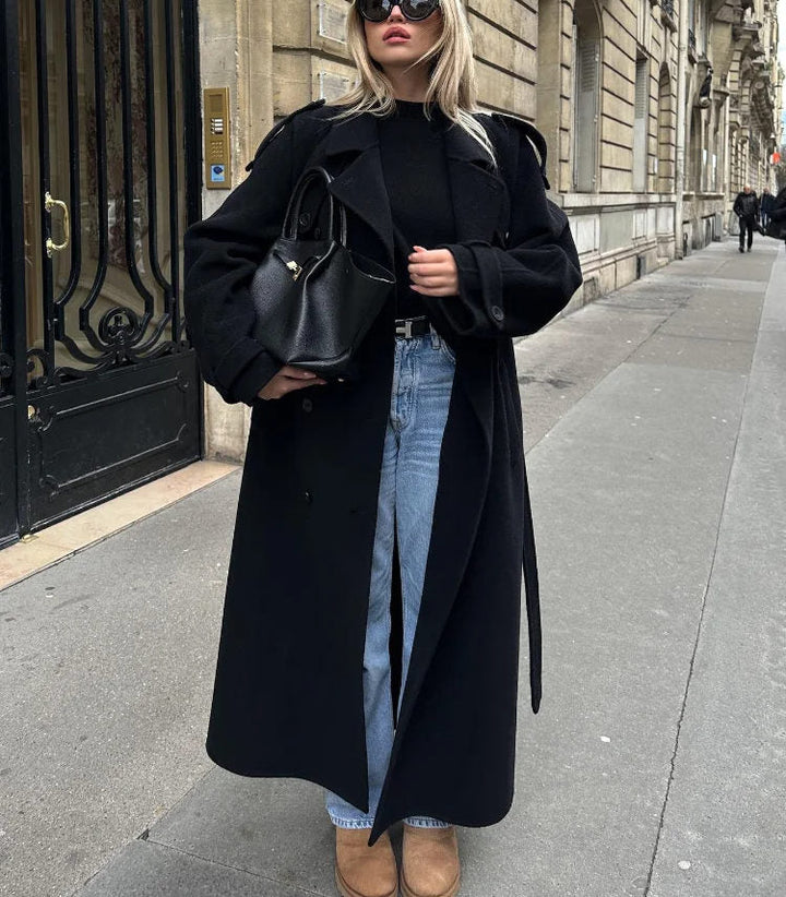 Women's black classic double-breasted trench coat, complete with a flattering belt. Sophisticated jacket.