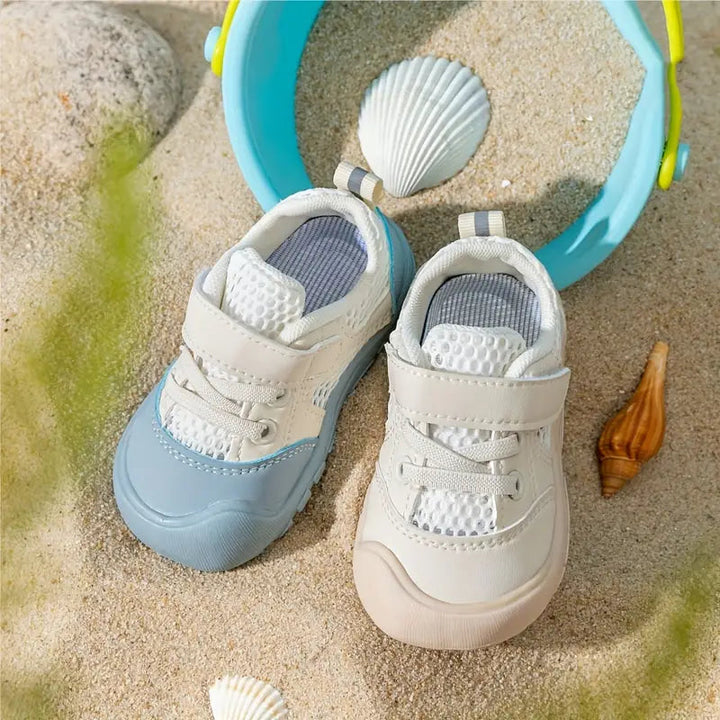 Beige toddler sneakers featuring a flexible sole for first steps.
