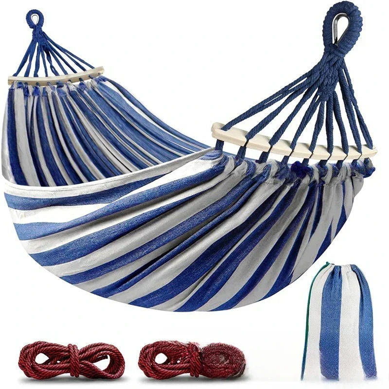 Blue & red striped double canvas hammock with wooden spreader bars, perfect for garden relaxation & outdoor living.