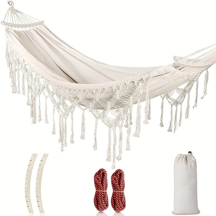 Bohemian double hammock with colorful stripes & tassels for outdoor patio relaxation.