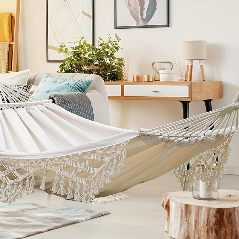 Relaxing outdoor cotton hammock, bohemian striped with tassels, for patio comfort.