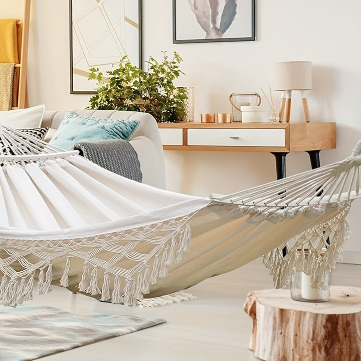 Relaxing outdoor cotton hammock, bohemian striped with tassels, for patio comfort.