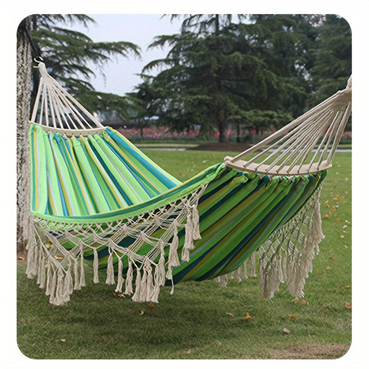 Striped double hammock with tassels, ideal for outdoor comfort & indoor coziness.