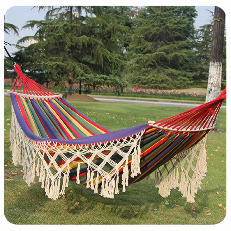 Indoor bohemian double hammock, soft cotton with stripes and tassels, for cozy relaxation.
