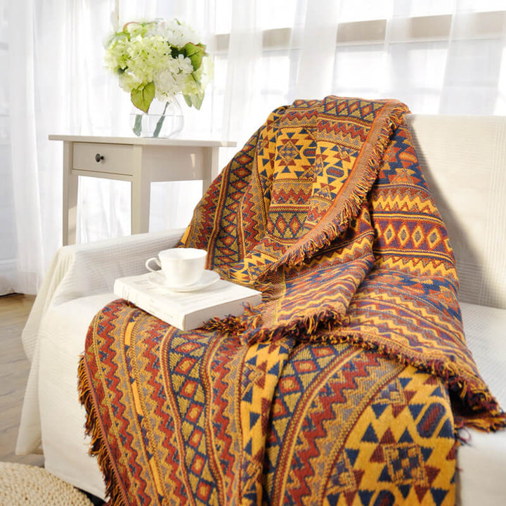 Hand-knitted look bohemian throw blanket with decorative tassels for home.