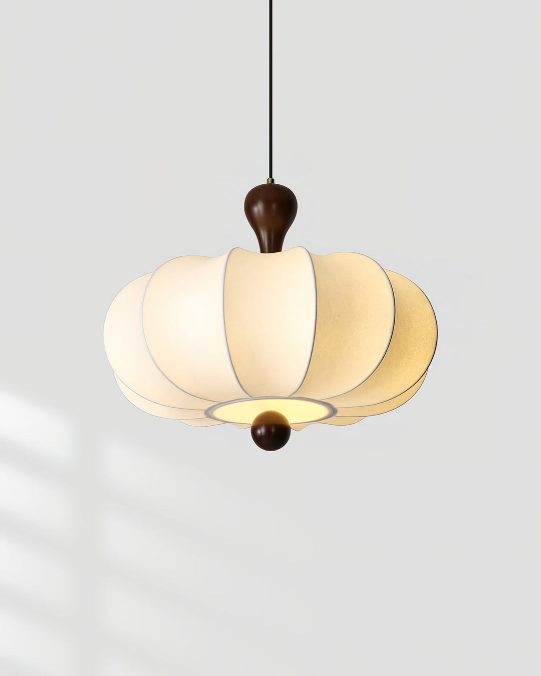 Striking Briael pendant light, crisp white fabric shade contrasts with rich walnut wood frame design.