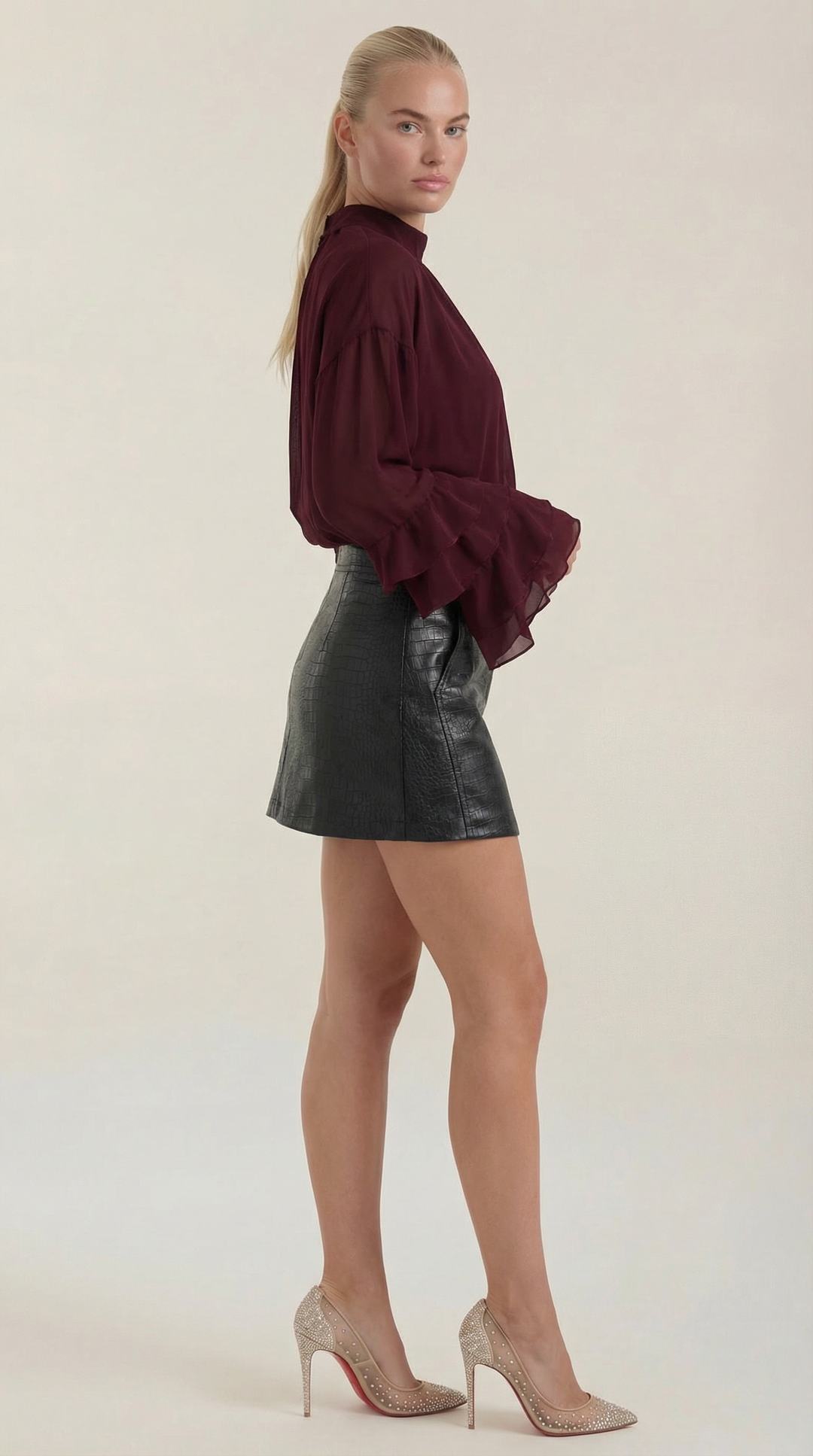 Elegant sheer blouse with mock neck and dramatic tiered ruffle sleeves in rich burgundy.