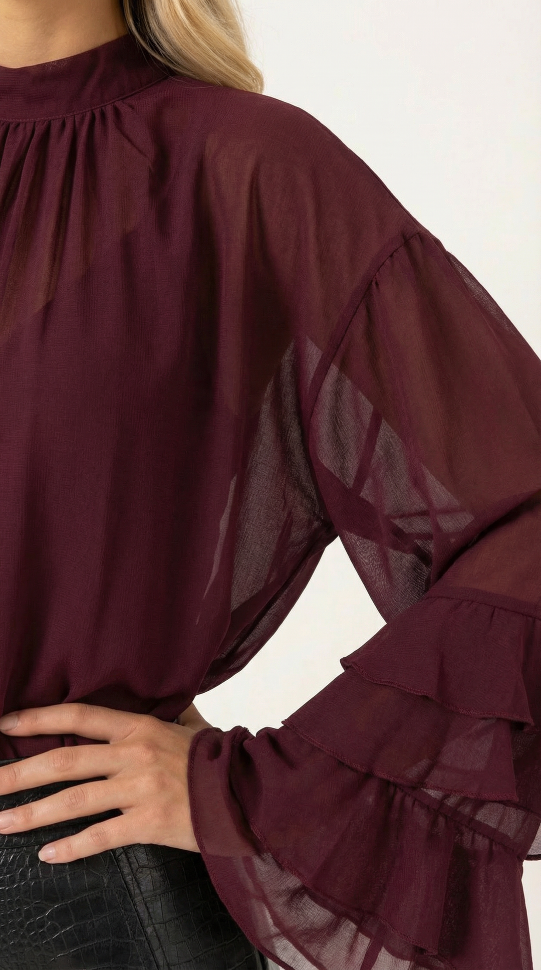 Statement women's fashion piece: a burgundy sheer top with layered ruffle sleeves.