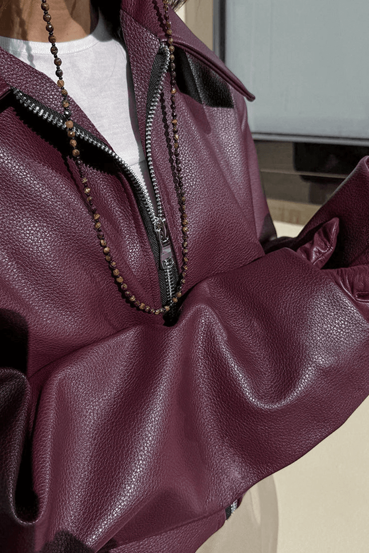 Model showcases a women's chic burgundy cropped jacket, trendy and perfect for modern fashion.
