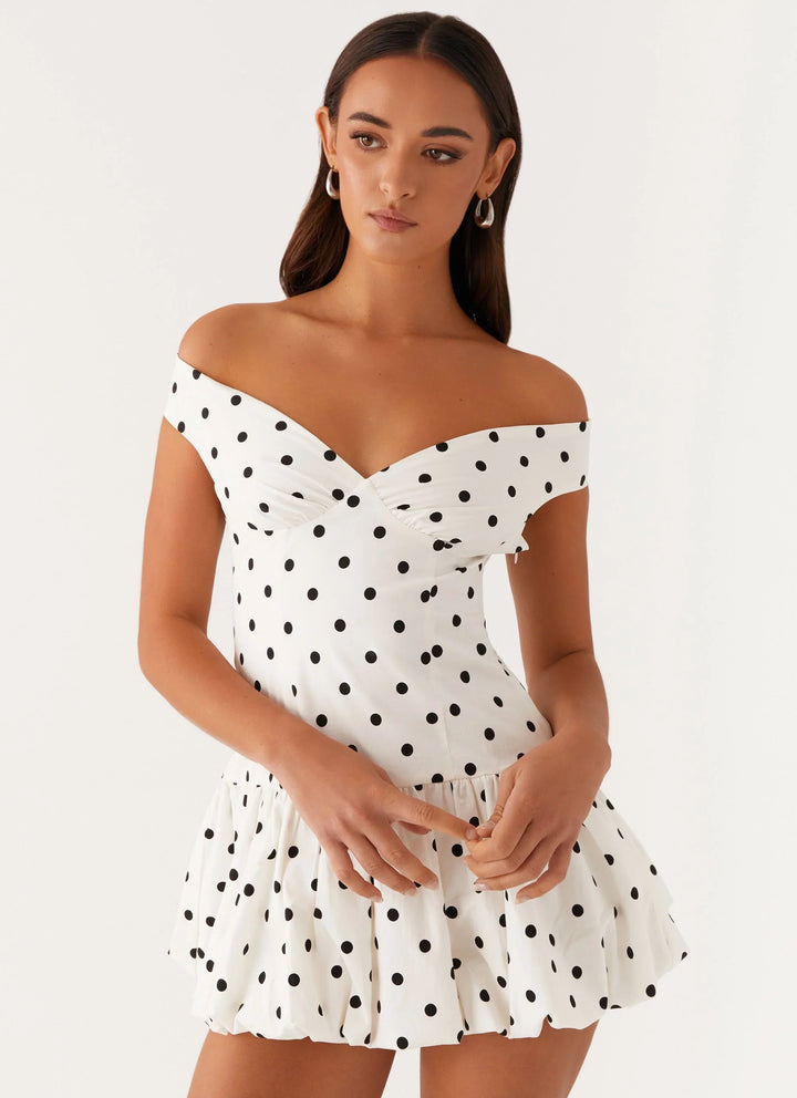 Chic off-shoulder polka dot peplum mini dress, perfect for summer parties.