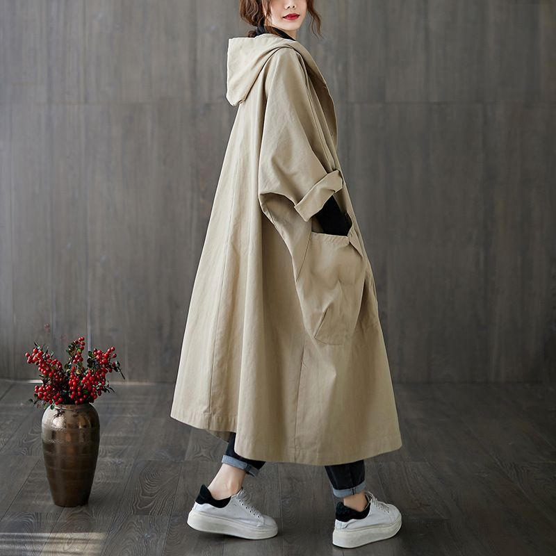 Woman in oversized waterproof windbreaker, staying dry and chic on a rainy spring day.
