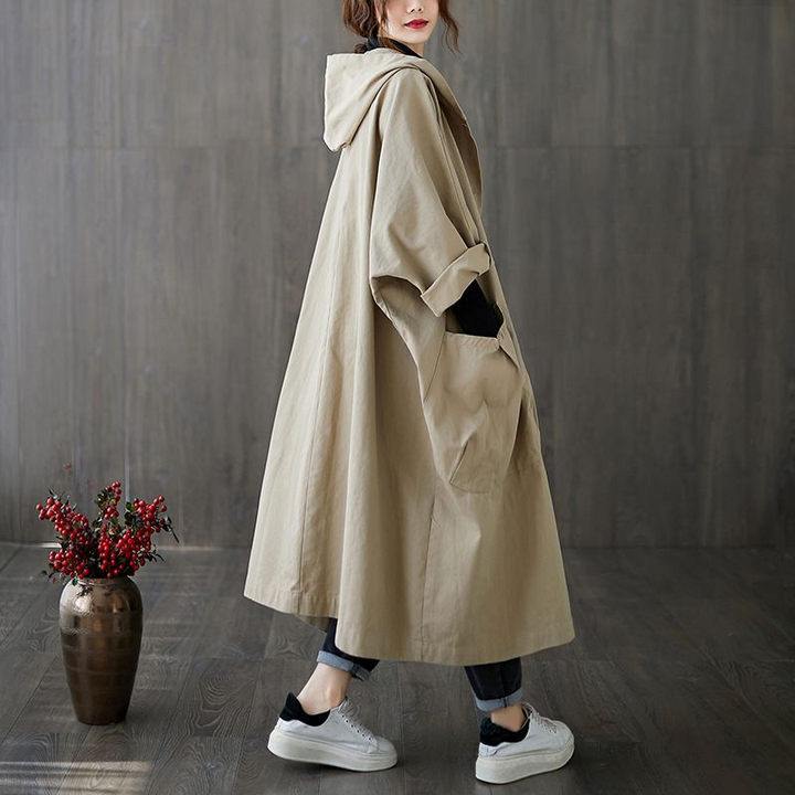 Woman in oversized waterproof windbreaker, staying dry and chic on a rainy spring day.