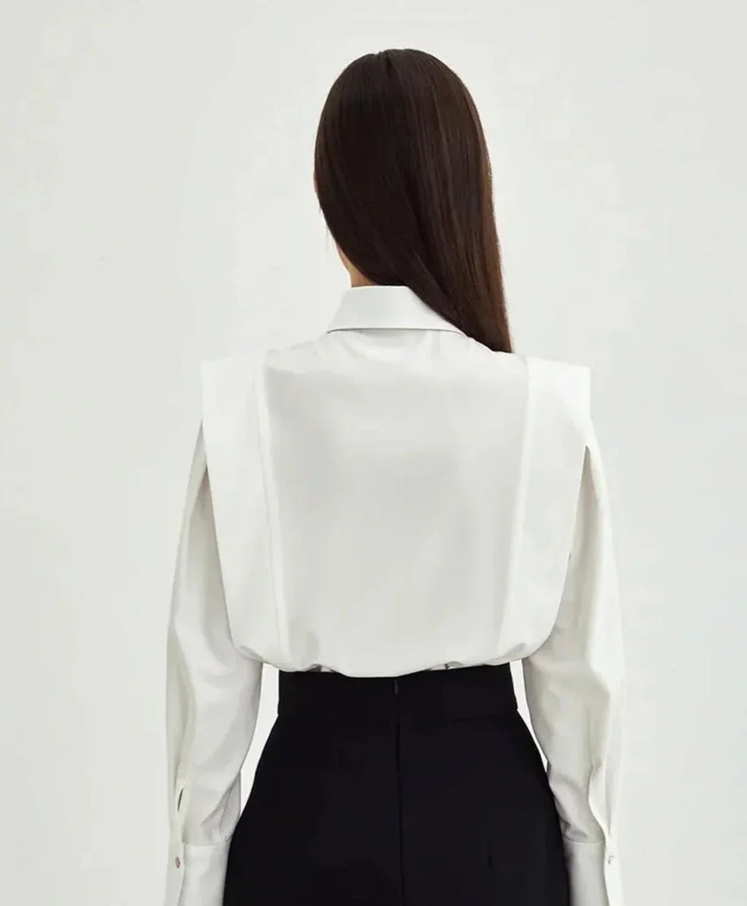 Close-up of a women's boxy button-down blouse, highlighting fabric texture and stylish buttons.