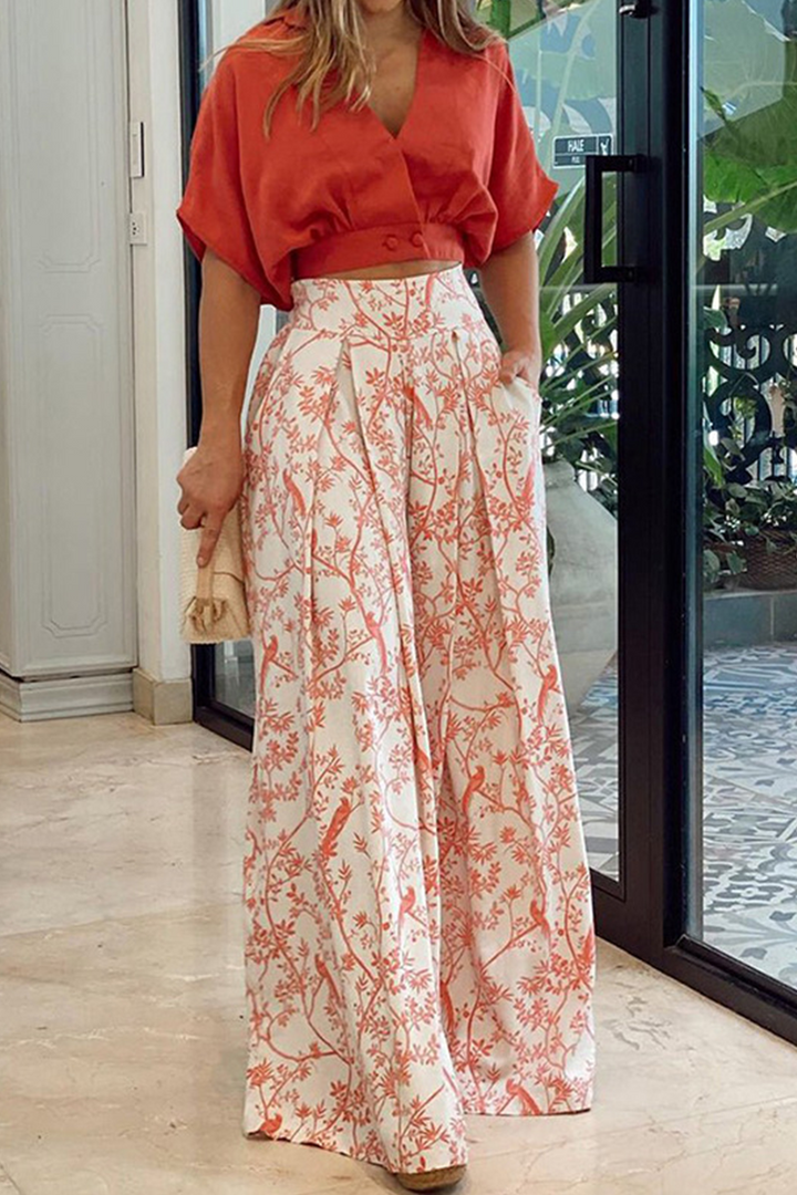 Vibrant floral print women's two-piece set: a stylish crop top and breezy wide-leg pants for summer fashion.