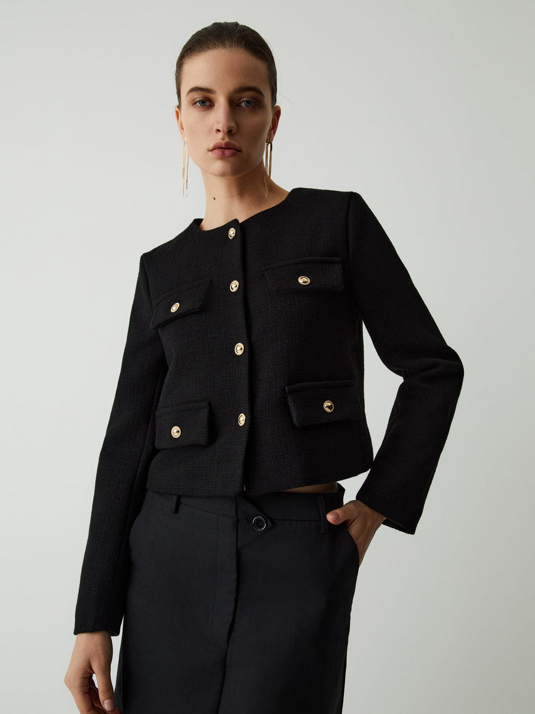 Elegant women's cropped jacket featuring chic gold buttons. Smart casual outerwear for a polished look.