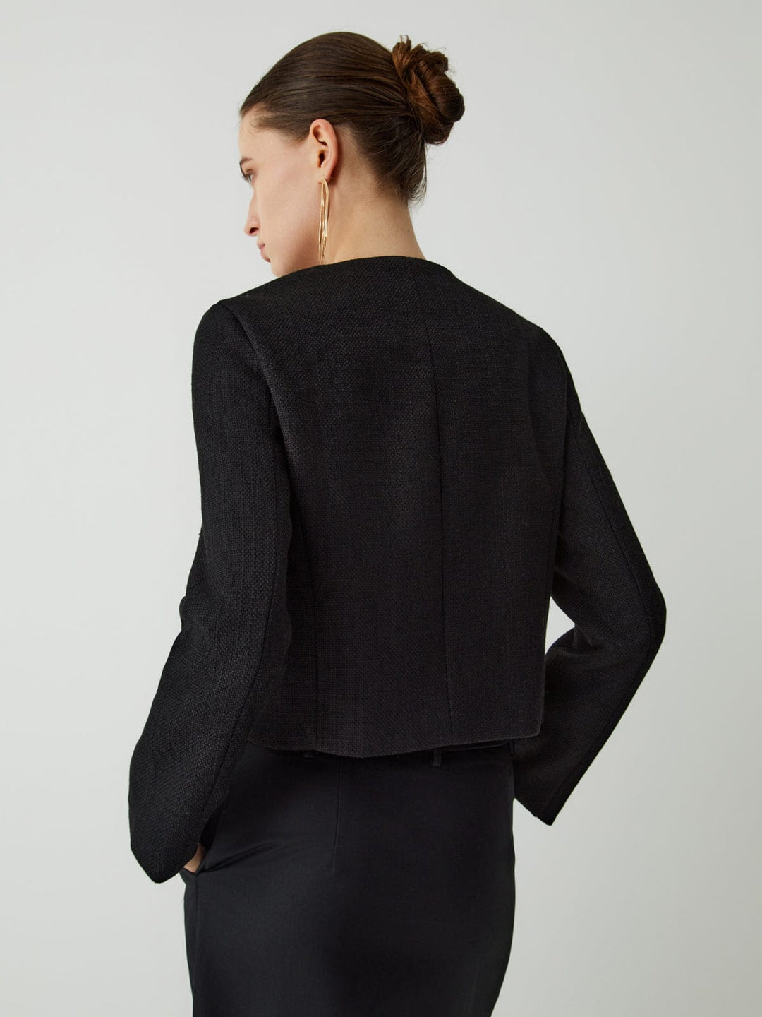 Chic women's cropped jacket, detailed with prominent gold buttons. Ideal for smart casual or elegant wear.