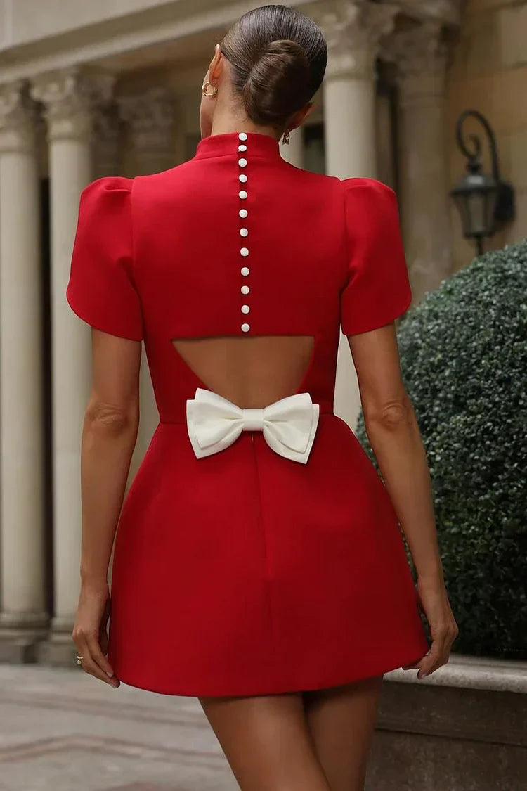 Side view of women's chic mini dress, flattering silhouette & elegant back bow detail. Versatile classic fashion.