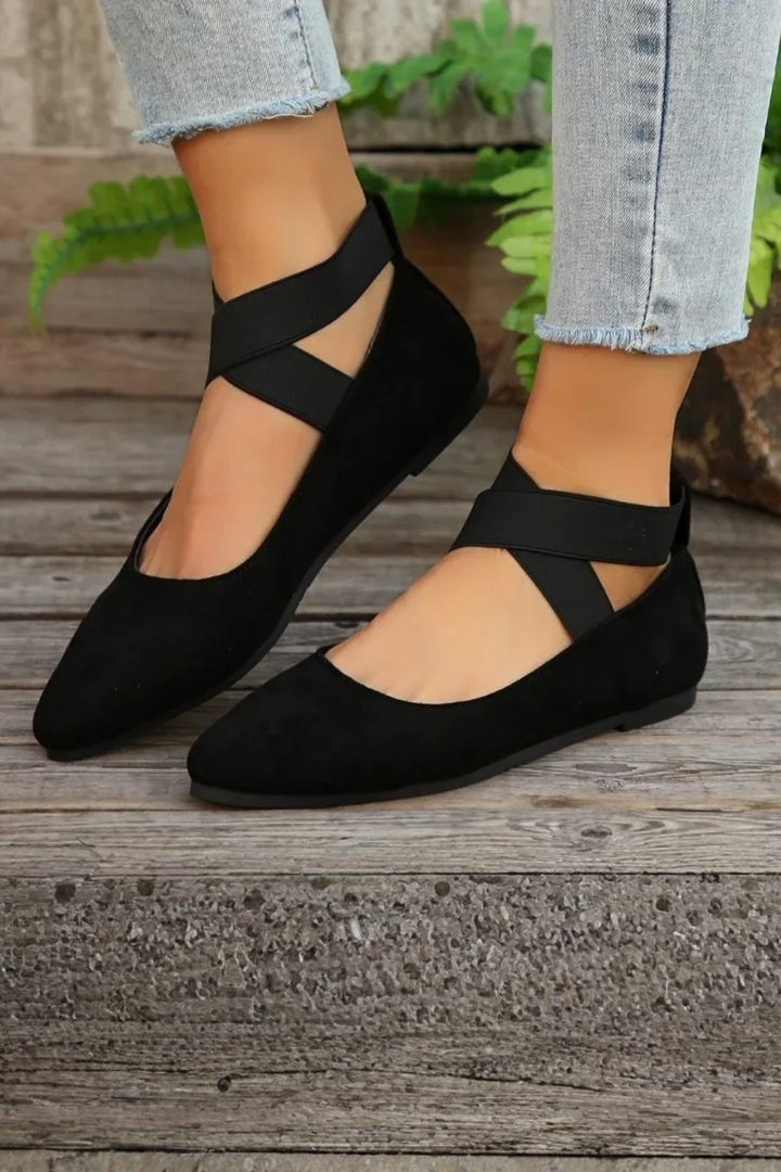 Sleek women's pointed toe ballet flats with a delicate ankle strap, offering modern casual elegance.