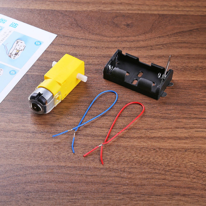 Child's hands assembling a wooden DIY electric boat, part of an educational kit.