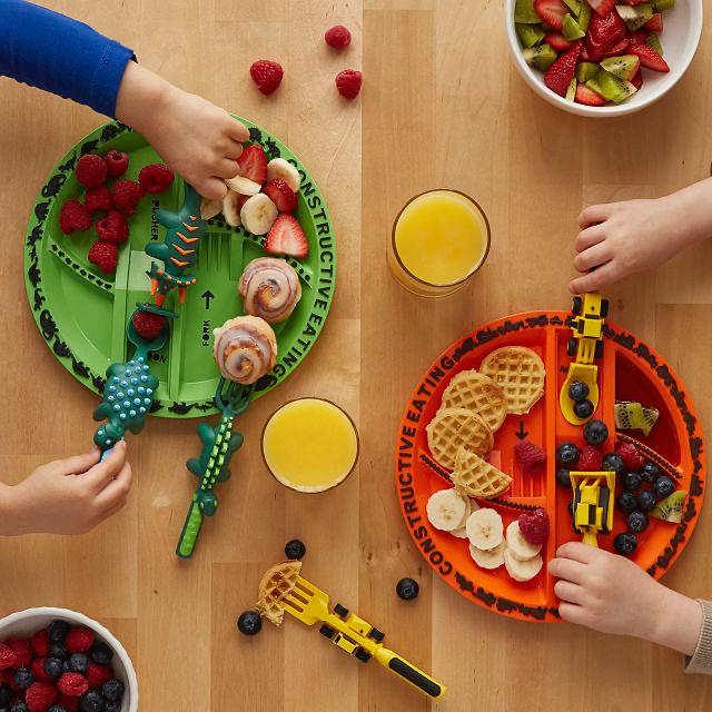 Kids' dinosaur-themed plate & utensil set, BPA-free, encouraging self-feeding.