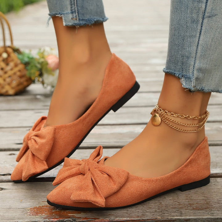 Comfortable red women's slip-on ballet flats, featuring a chic bow, ideal for all-day smart casual style.