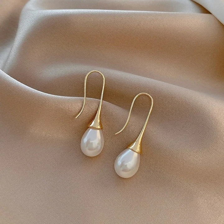 Simple design women's pearl earrings with lustrous white pearls, an elegant classic jewelry accessory.