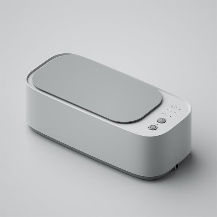 Ultrasonic cleaner in action, a watch and ring visible inside, bubbles indicating deep cleaning. Perfect for delicate items.