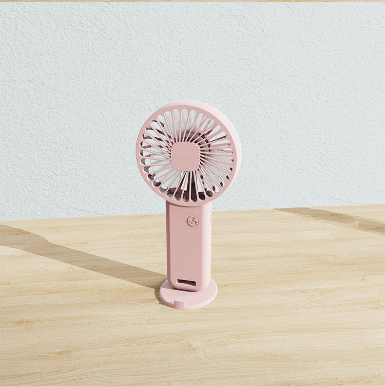 Small portable rechargeable fan, versatile for desk, travel, or hands-free personal cooling.