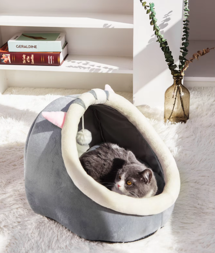 Cozy igloo cat bed cave with a playful hanging ball for feline comfort and hideaway.