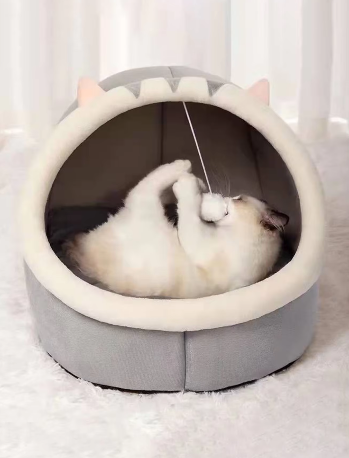 Interactive cat igloo bed with a dangling play ball, encouraging feline fun and rest.