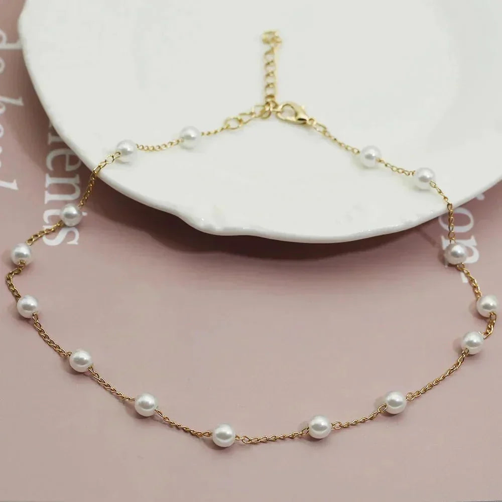 Women's elegant gold-tone dainty pearl choker necklace. Perfect fashion accessory for a sophisticated look.