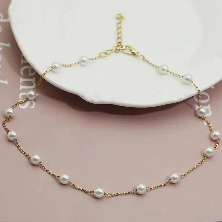 Women's elegant gold-tone dainty pearl choker necklace. Perfect fashion accessory for a sophisticated look.
