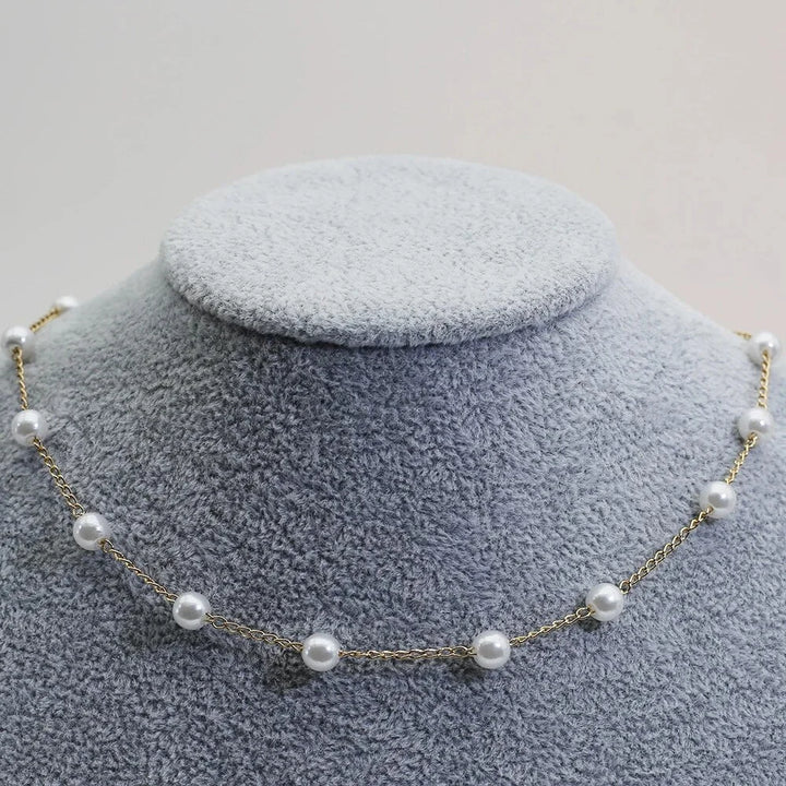 Delicate gold-tone women's choker necklace featuring small, luminous pearls. Dainty and fashionable jewelry.
