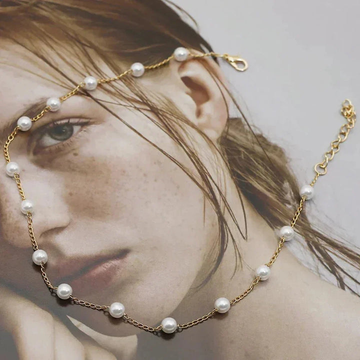 Fashionable women's gold-tone pearl choker necklace. Dainty jewelry accessory for an elegant style.