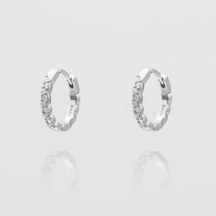 Shiny silver plated huggie hoop earrings for women, a minimalist and chic jewelry accessory.