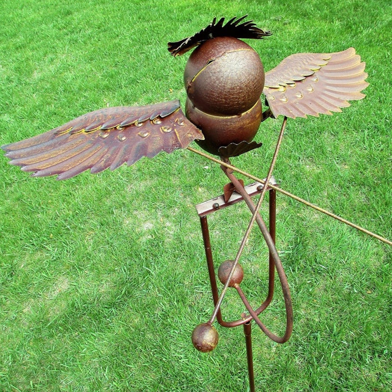 Wrought iron metal bird wind spinner, a unique garden decor and yard sculpture for outdoor spaces.