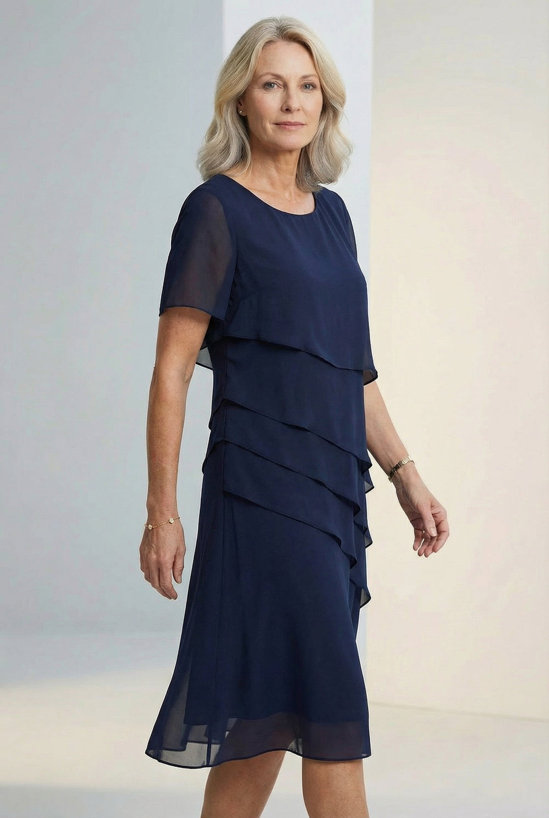 Close-up of the soft fabric and delicate ruffles on the Elarisse elegant midi dress.