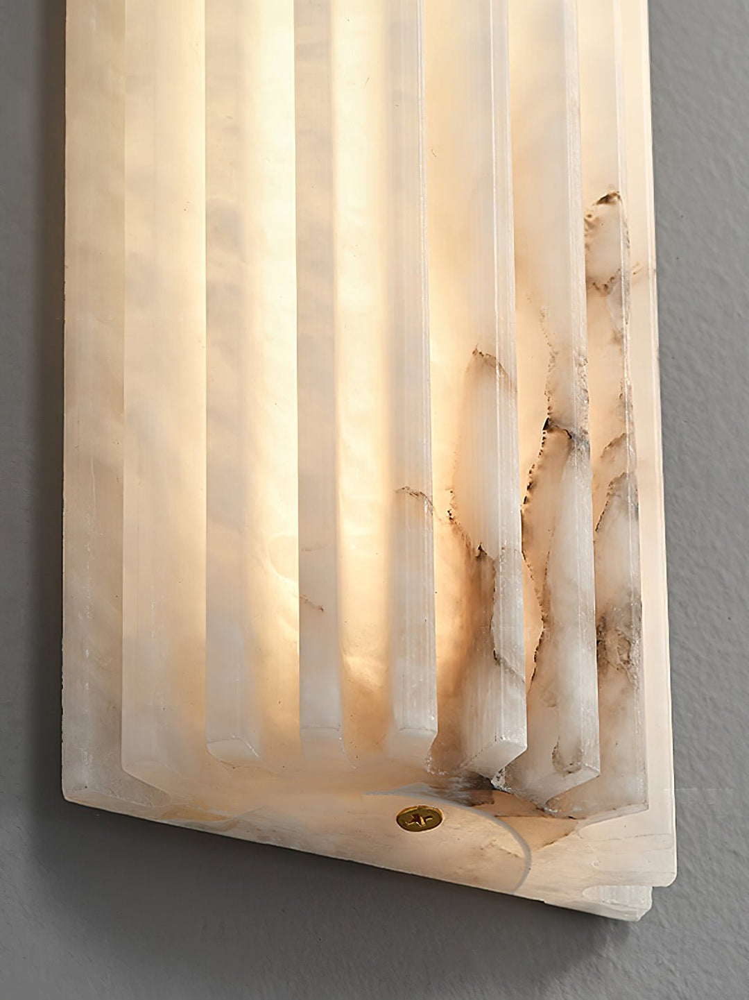 Smooth alabaster LED wall light, offering a warm glow for modern bedroom lighting.