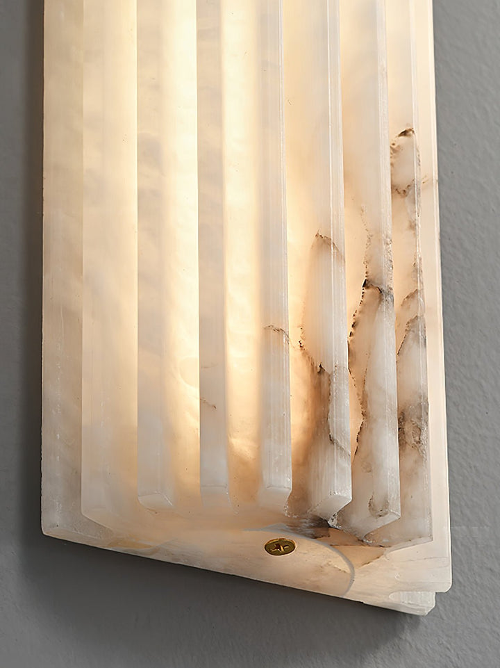 Smooth alabaster LED wall light, offering a warm glow for modern bedroom lighting.