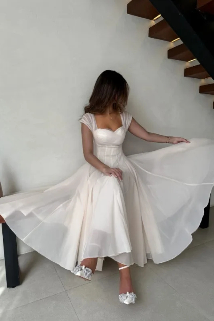 Women's A-line midi wedding guest dress featuring a sweetheart neckline & stylish cap sleeves. Semi-formal elegance.
