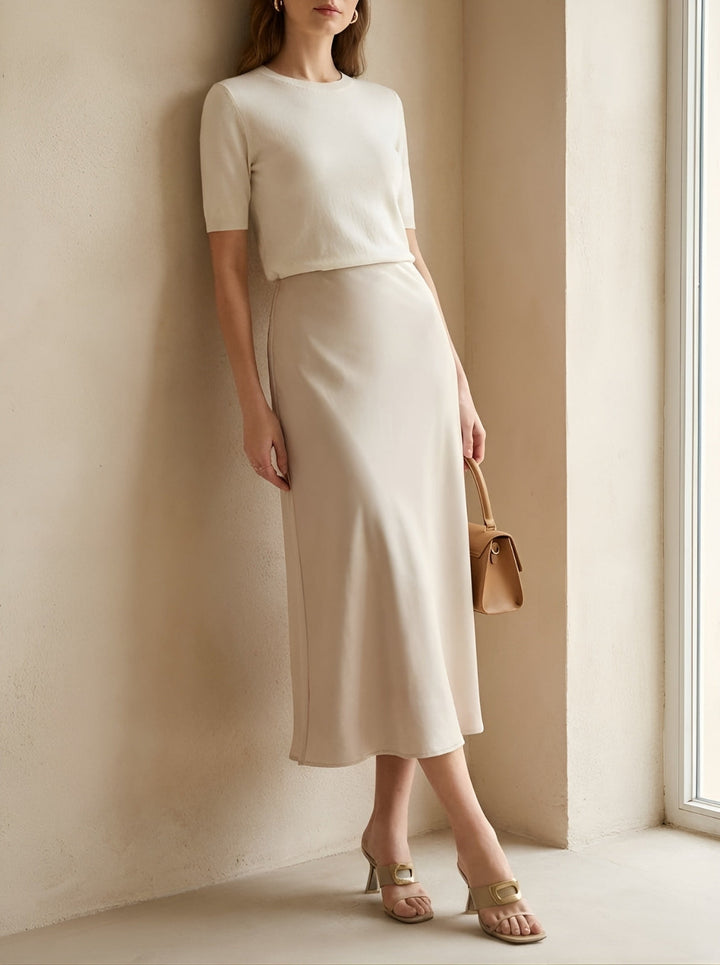 Women's versatile beige A-line midi skirt with high-waist design, a timeless fashion piece for summer outfits.