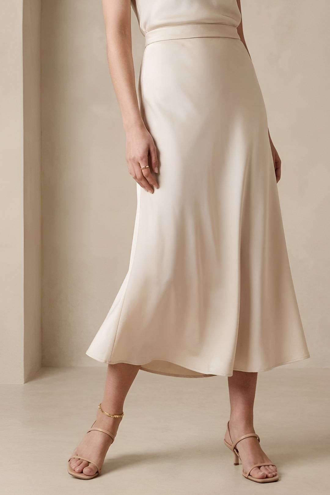 Fashionable women's beige midi skirt, a high-waisted A-line design, ideal for versatile spring and summer wear.