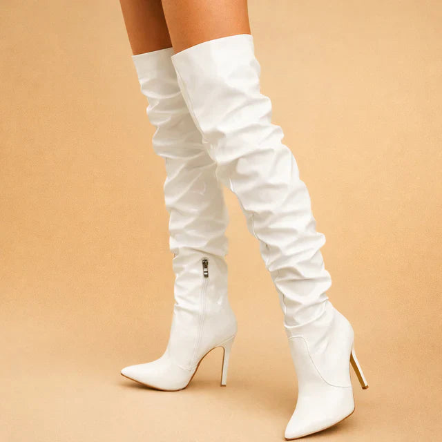 Close-up of elegant over-the-knee boots for women, highlighting chic ruching, pointed toe, and slender stiletto heel.